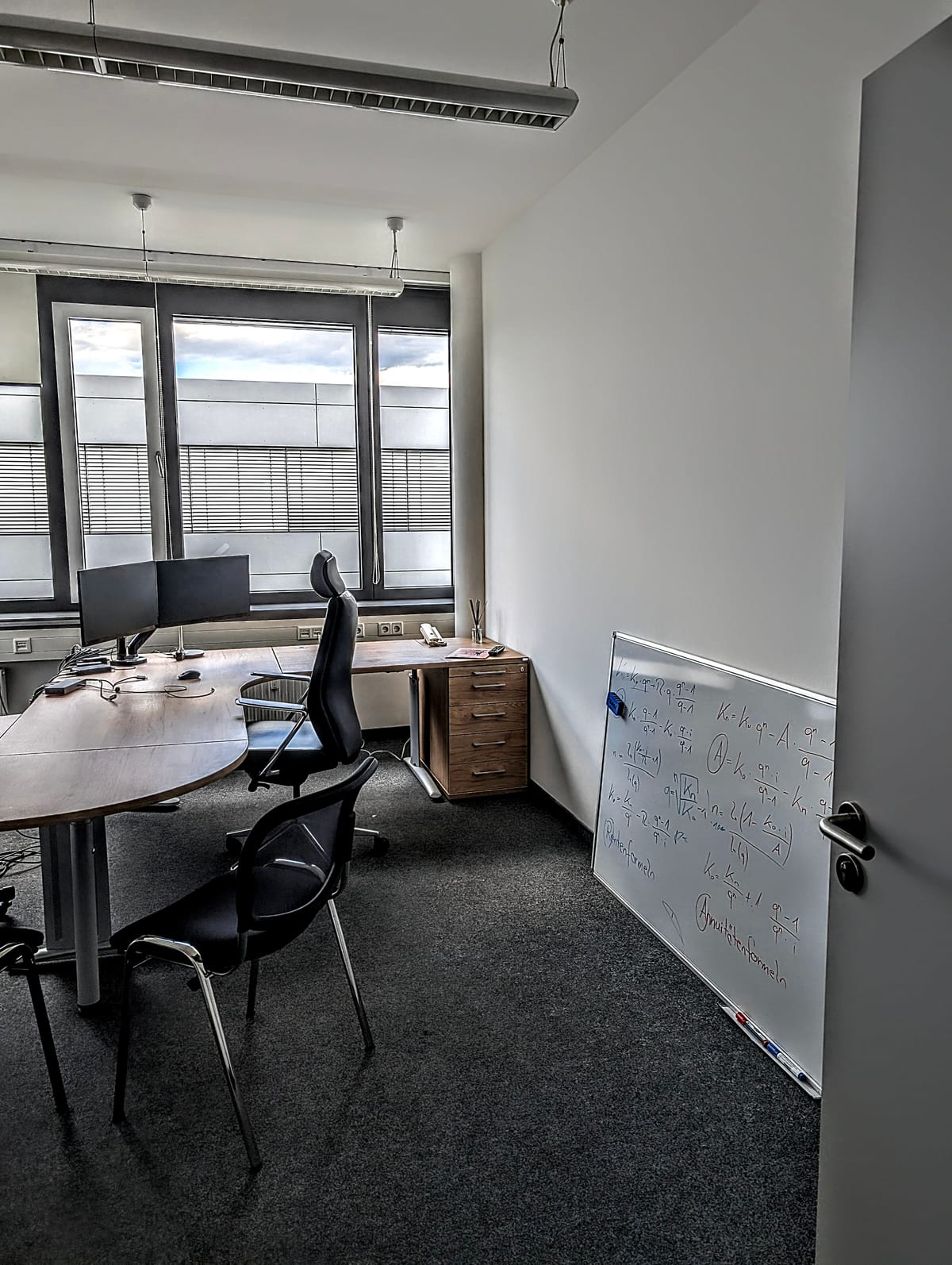 Beratungsbereich von optimal-versichert in der Henkestraße 91 mit Schreibtischen und Whiteboard